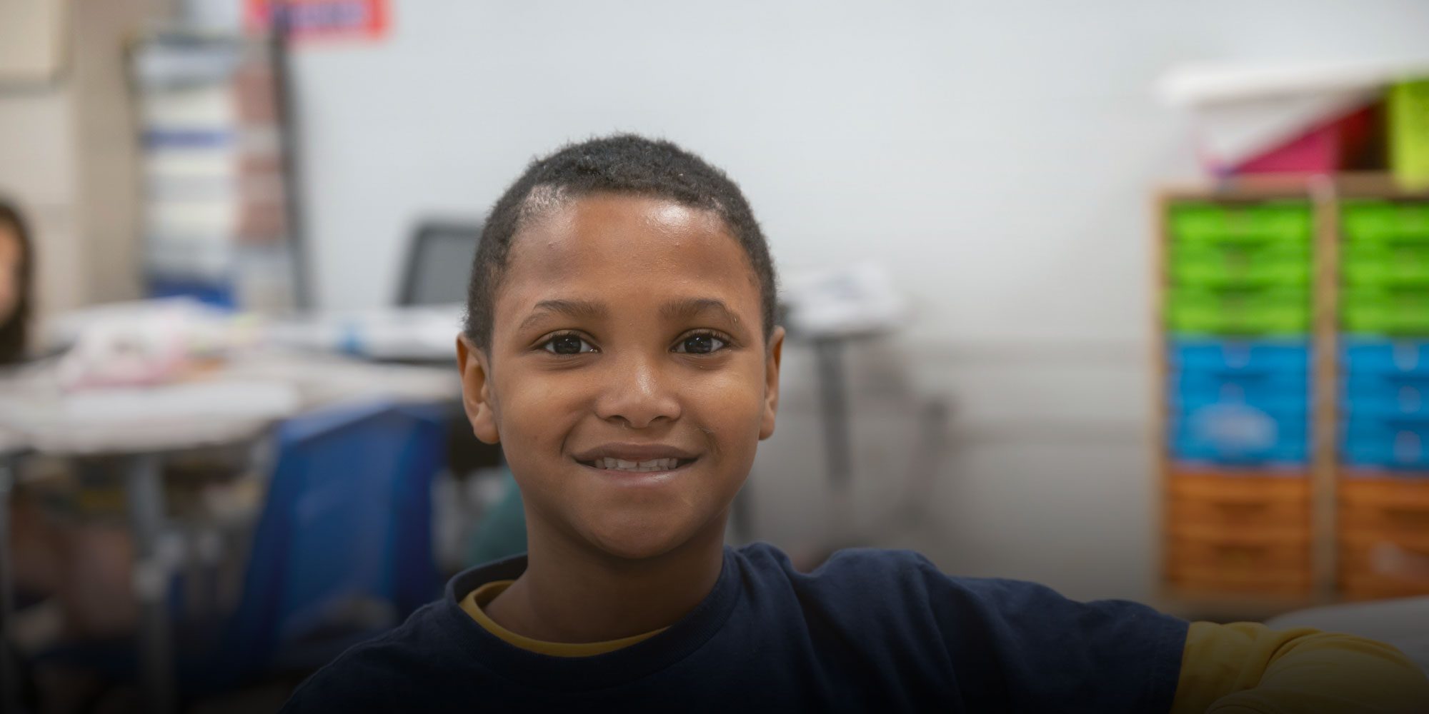 Smiling Sheffield Academy student in a classroom.