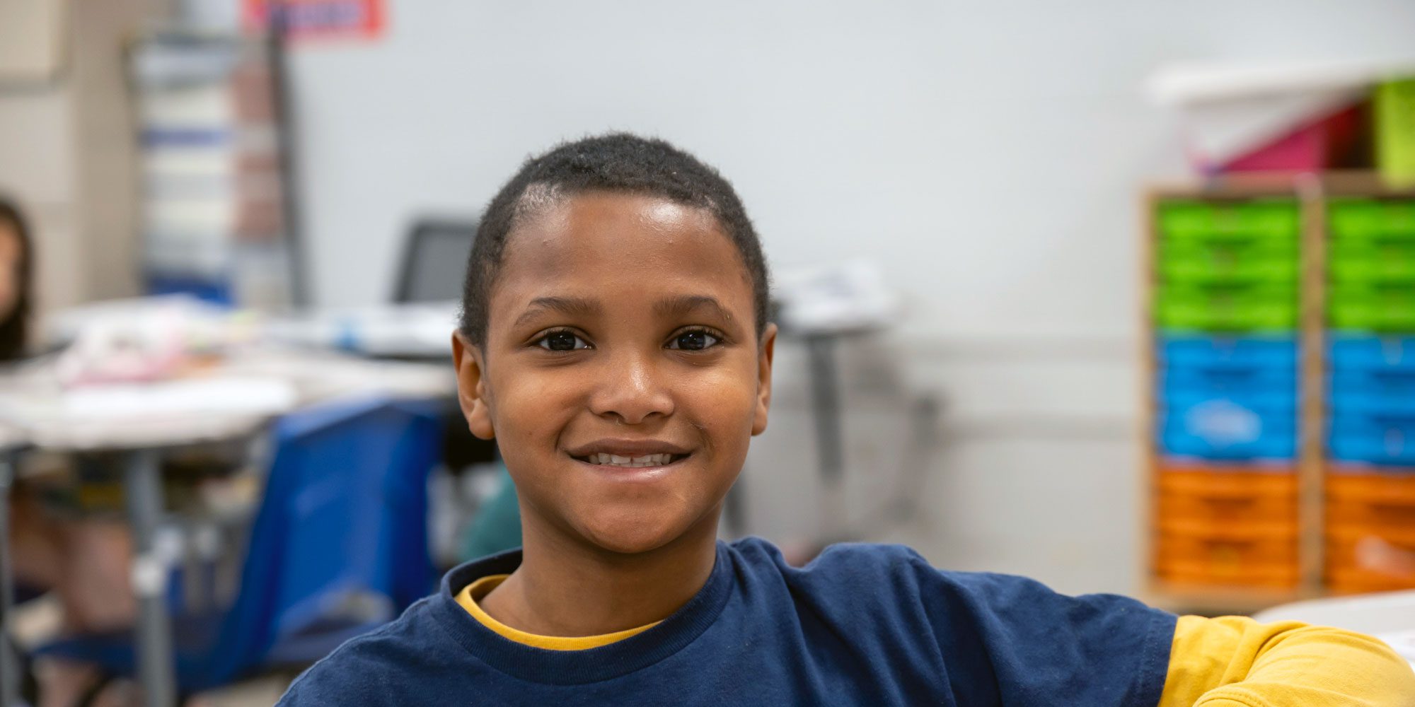 Smiling student in a classroom.